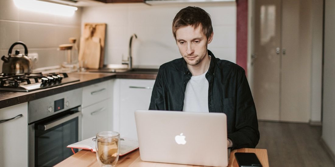 man working from his kitchen table at home