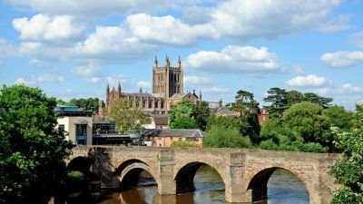 A picture of the bridge over the River Wye in Hereford city centre with Hereford cathedral in the background